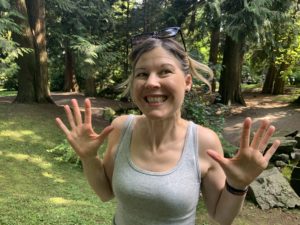 Excited woman in the woods with jazz hands