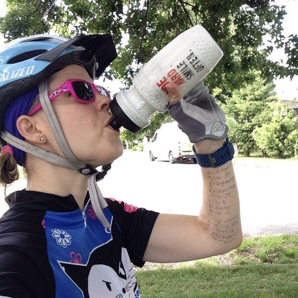 Female cyclist drinks from her water bottle during T1D and sport