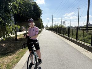 Cyclist with type-1 diabetes, stops to make some insulin pump adjustments on her Tandem t:slim pump