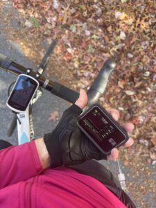 Cyclist holds Tandem t:slim x2 with Control IQ in her hands with front of white and blue road bike in the foreground